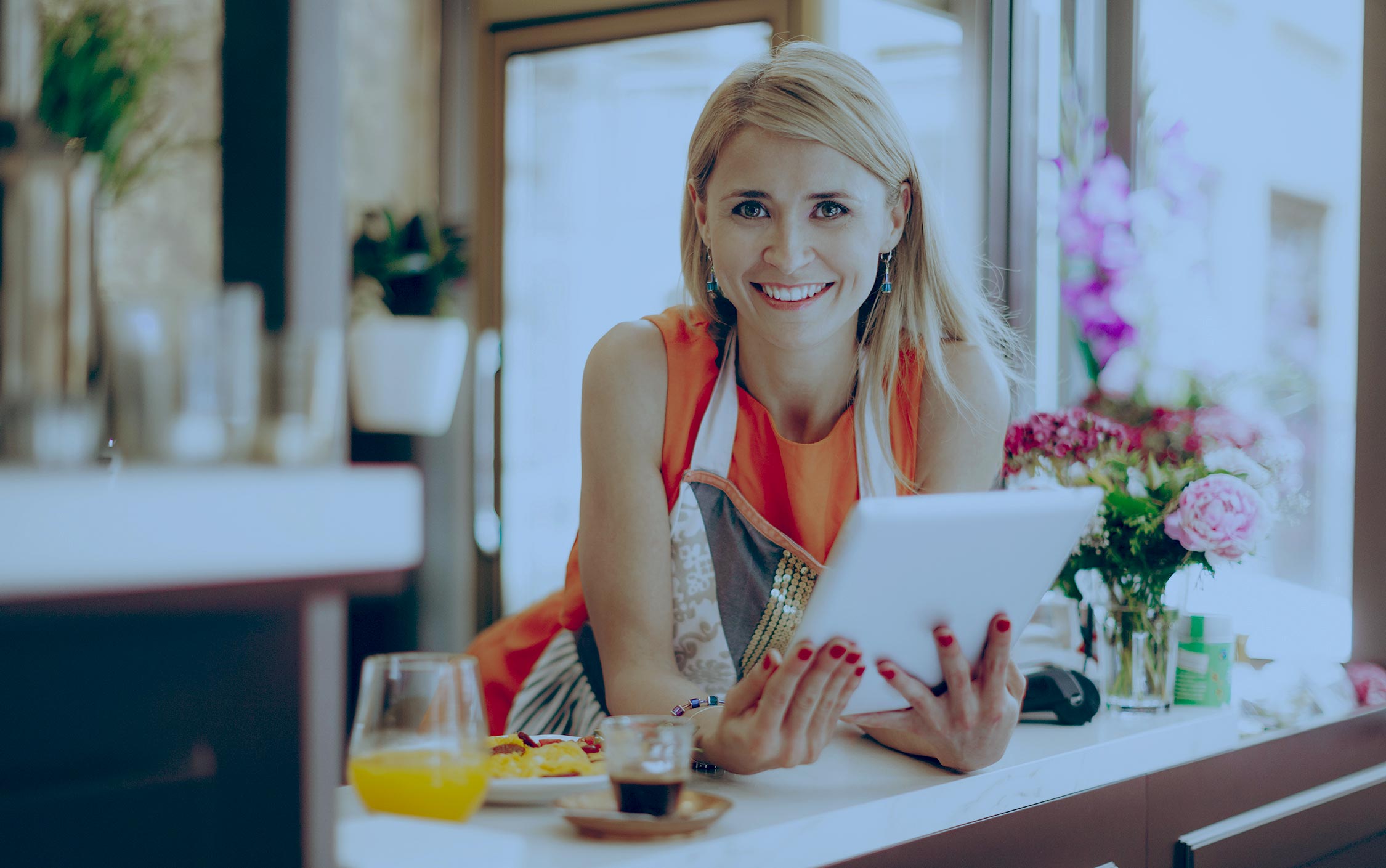 Woman leaning on counter with ipad in hand